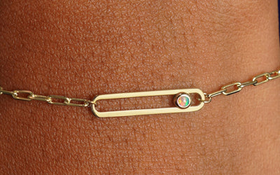 Close up view of a model's wrist wearing a yellow gold opal Dancing Gemstone Bracelet