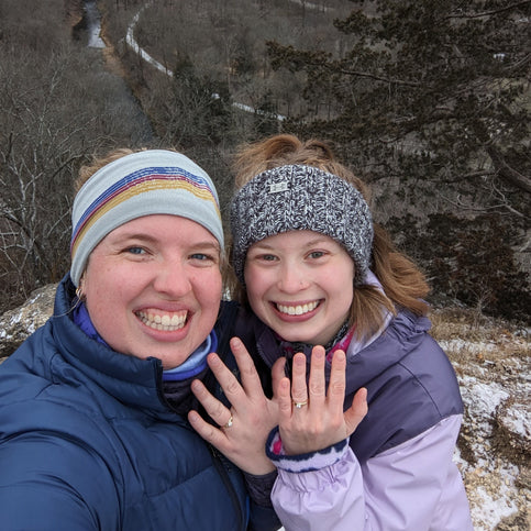 Two customers on a wintery hike showing off their Automic Gold custom rings