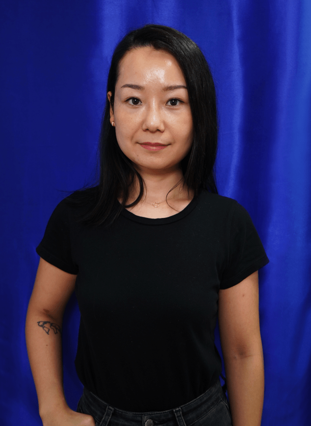 Automic Gold CAD Designer April Wang posing in front of a dark blue background