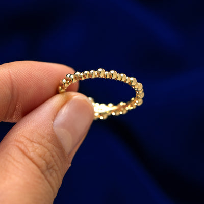 A model holding a diamond bubble fidget ring between two fingers to show the details on the bottom of the band