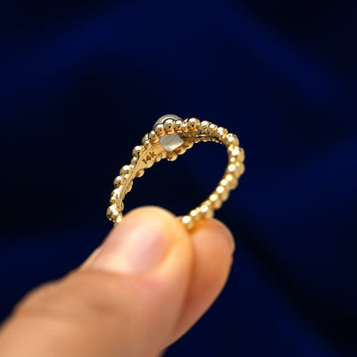 A model holding a diamond bubble fidget ring between two fingers to show underneath the gem