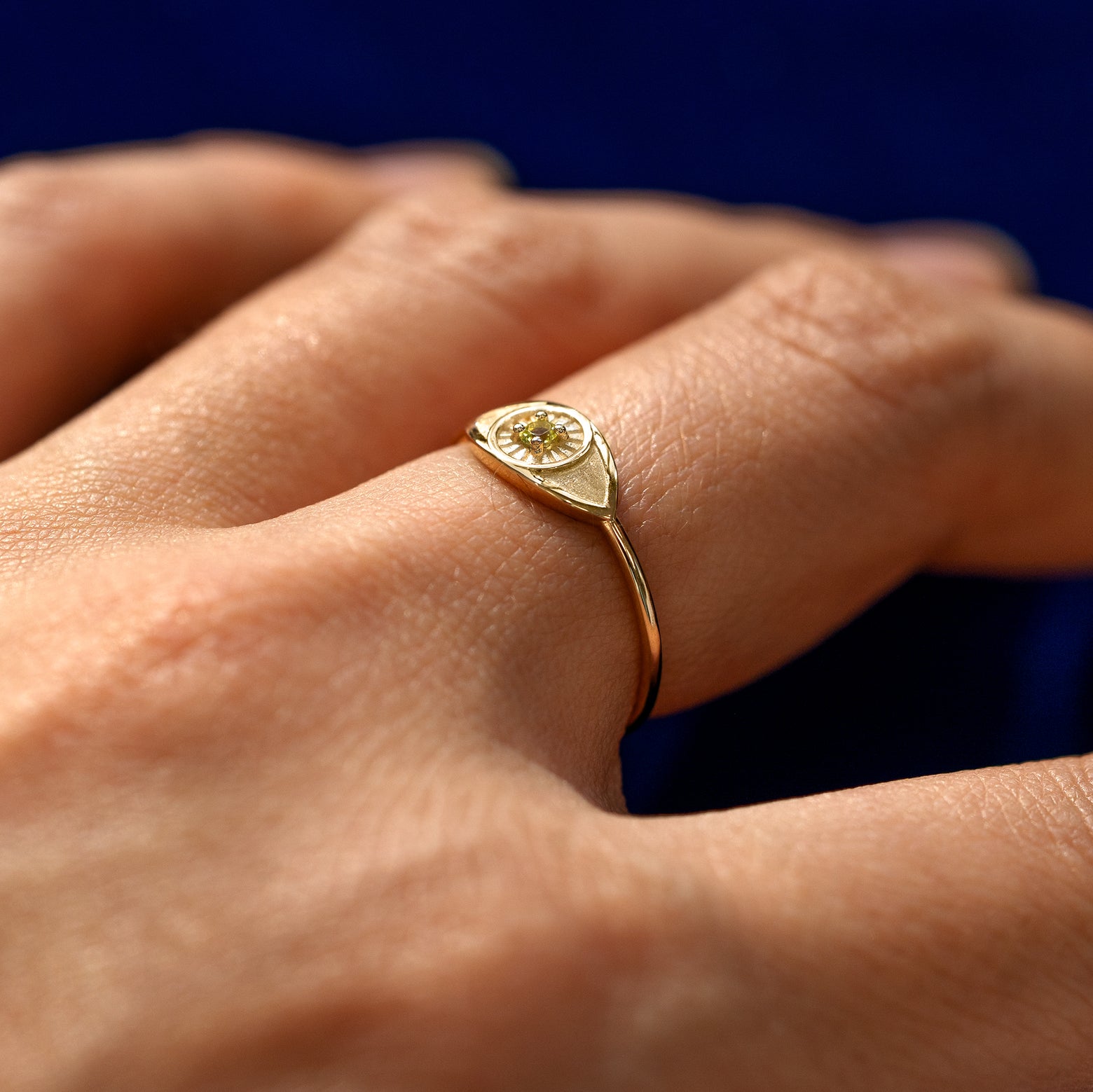 Side view of a Ruby Gemstone Evil Eye Ring on a model's finger