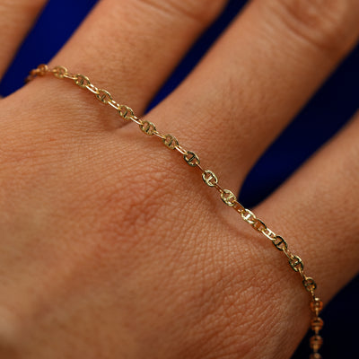 A yellow gold Flat Mariner Chain Bracelet on the back of a model's hand to show the details of the links