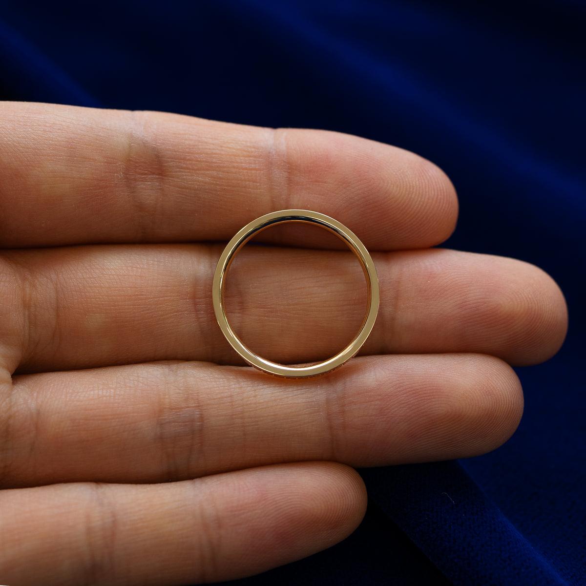 A geometric grass band lying flat in a models hand to show the thickness of the ring