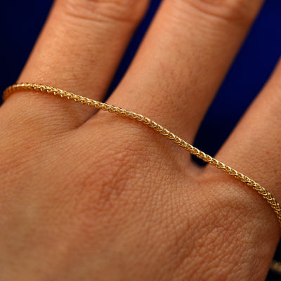 A yellow gold Mini Franco Chain Anklet on the back of a model's hand to show the details of the links