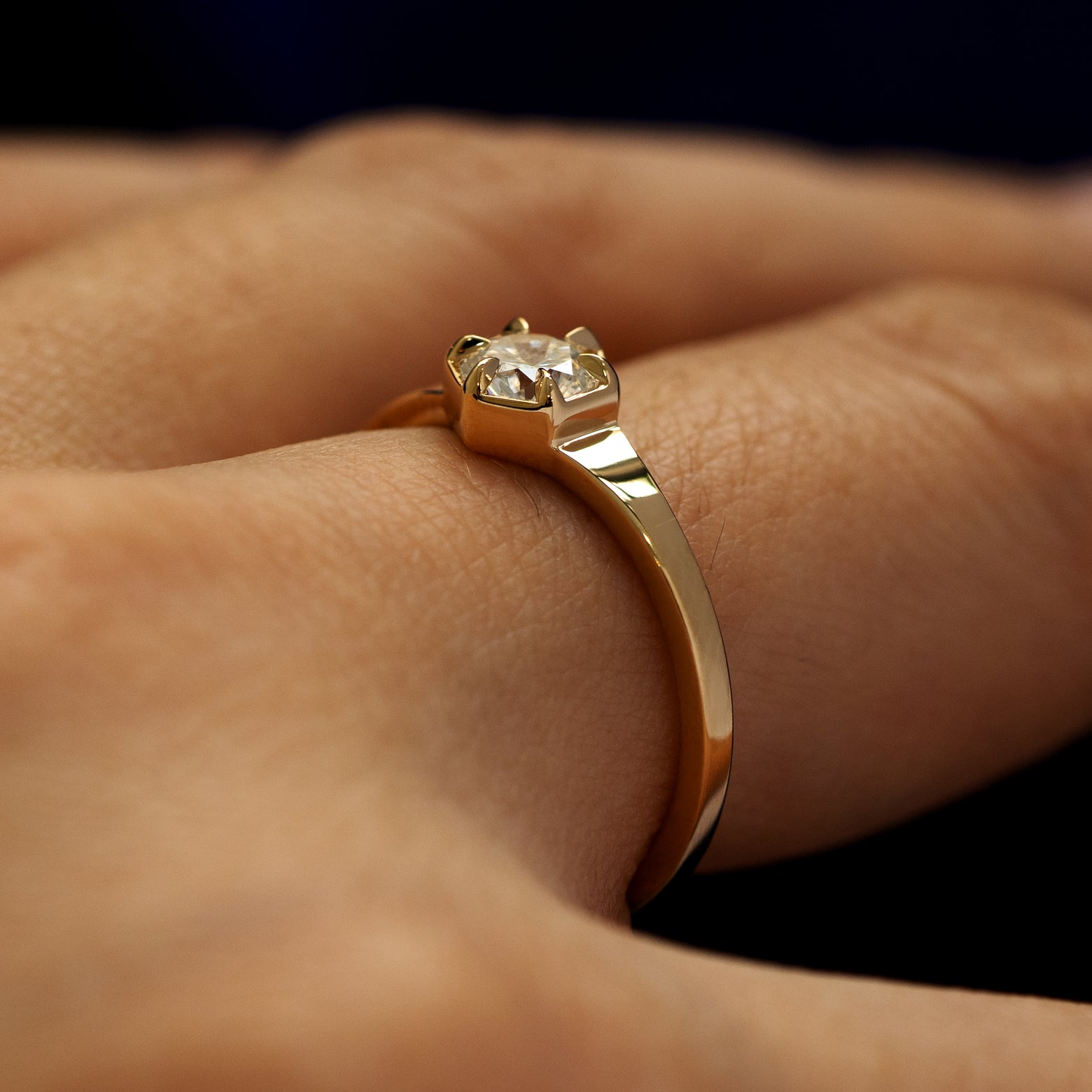Side view of a round diamond hexagon signet ring on models finger to show the  details of the gemstone and setting
