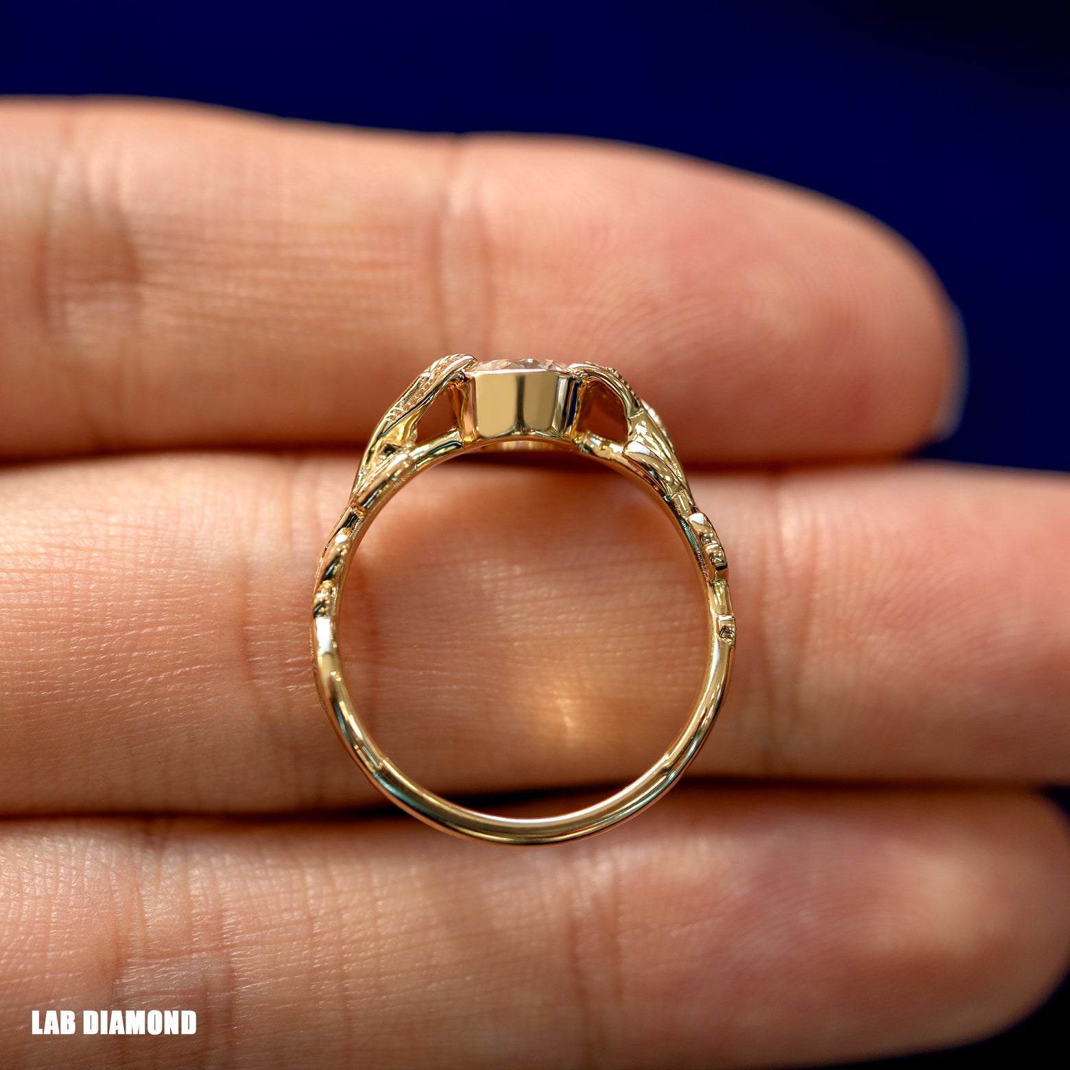 A yellow gold Lab Diamond Leaves Ring in a model's hand showing the thickness of the band