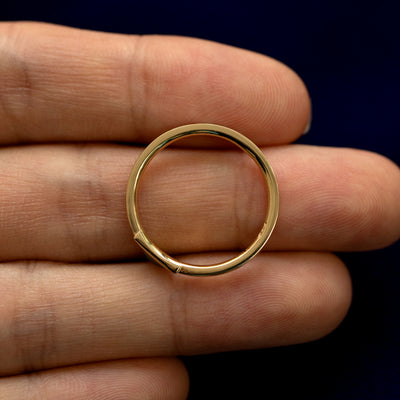 A Triangle Diamond Ring laying in a model's hand to show the thickness of the band