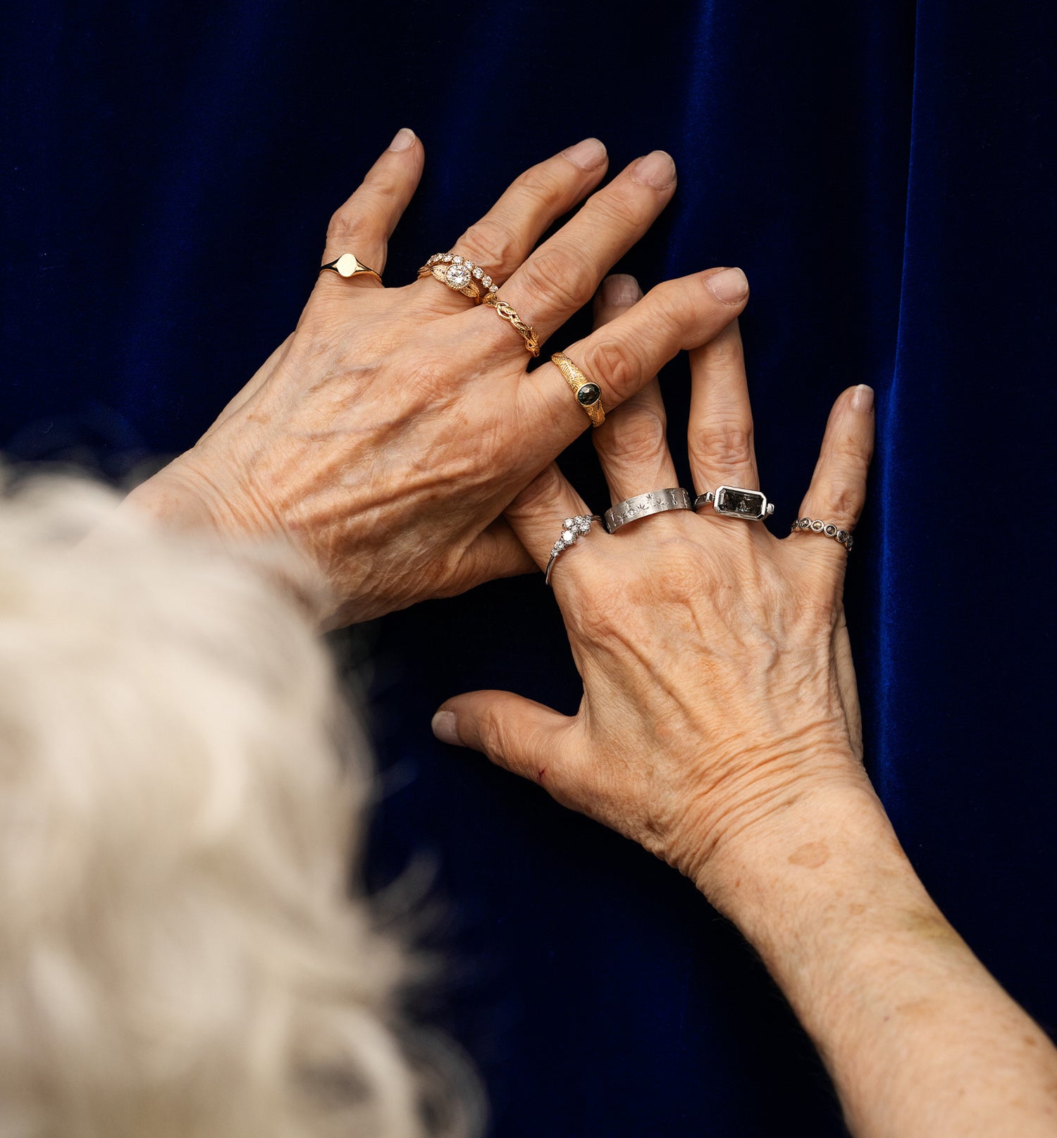 An older model wearing different Automic Gold rings on both hands