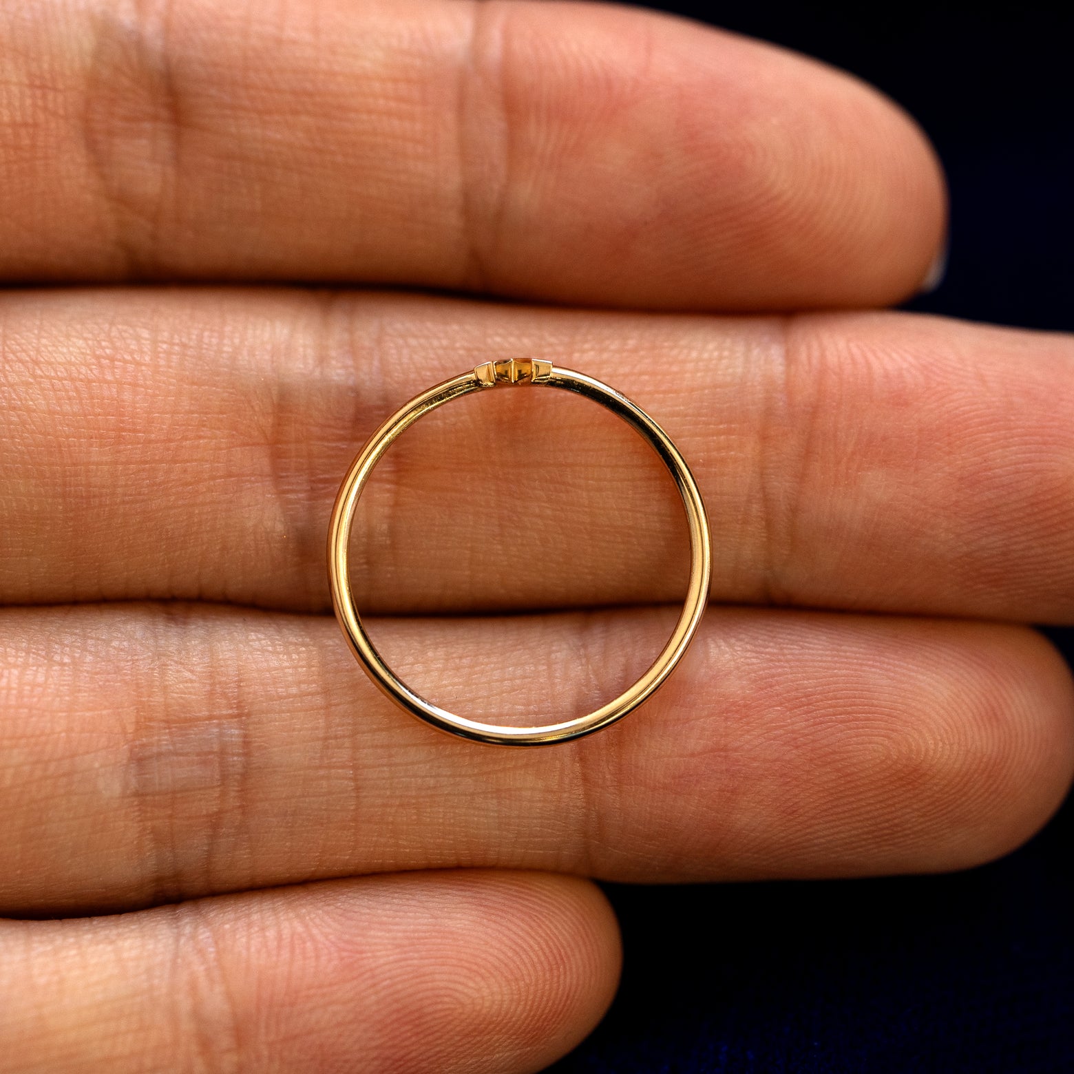 A solid gold 8 pointed star ring laying in a model's palm to show the thickness of the band