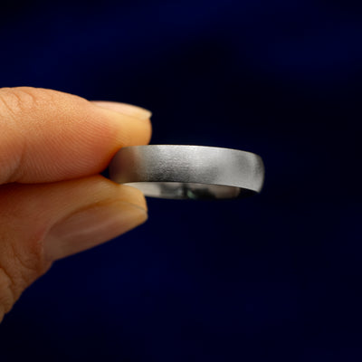 A model holding a Silver Curvy Matte Band tilted to show the details of the matte finish