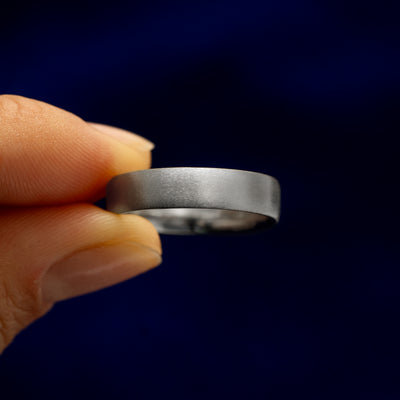 A model holding a Silver Mix Matte Band tilted to show the side of the ring
