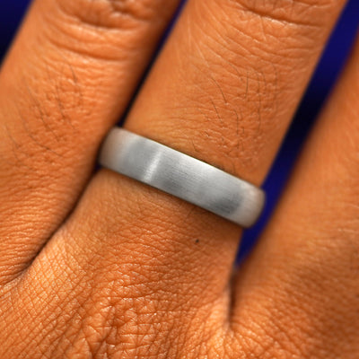 Close up view of a model's fingers wearing a 4mm 925 silver Curvy Matte Band