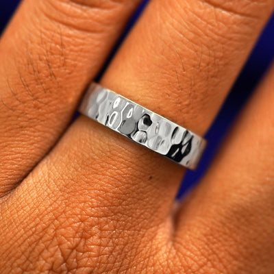 Close up view of a model's fingers wearing a 4mm 925 silver Industrial Hammered Band