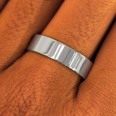 Close up view of a model's fingers wearing a 6mm 925 sterling silver Industrial Mirror Band