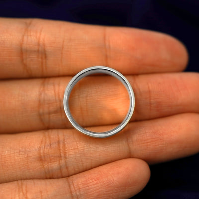 A Silver Industrial Stardust Band in a model's hand showing the thickness of the band
