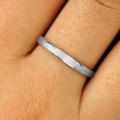 Close up view of a model's hand wearing a solid silver Beveled Edge Band
