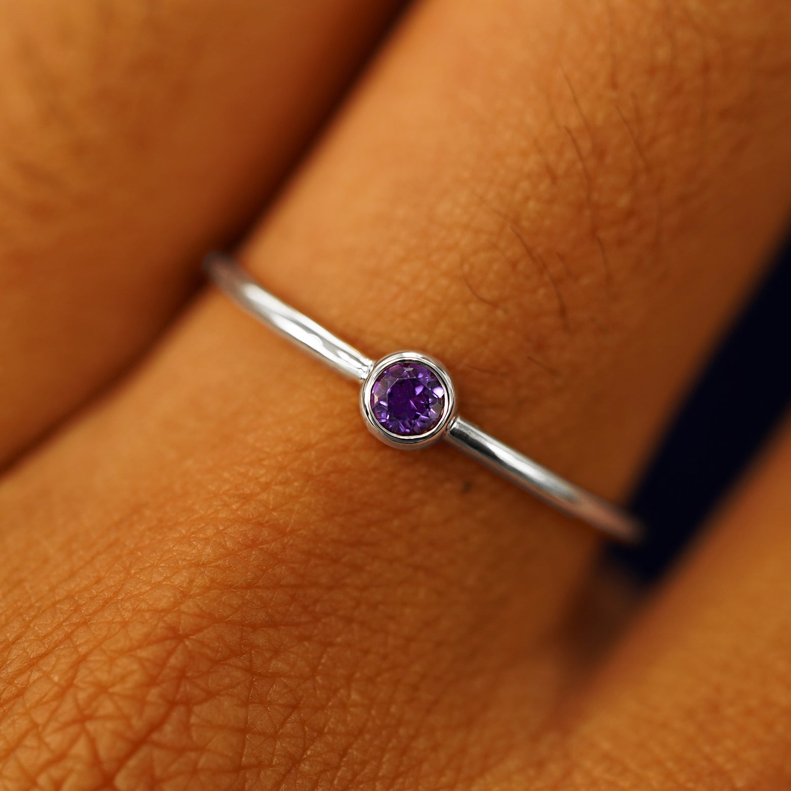 Close up view of a model's hand wearing a 950 platinum Amethyst Ring