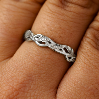 A solid 950 platinum braided leaves and vines ring on a model's finger