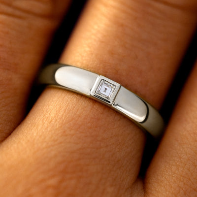 Close up view of a model's fingers wearing a 950 platinum Square Carre Cut Diamond Band