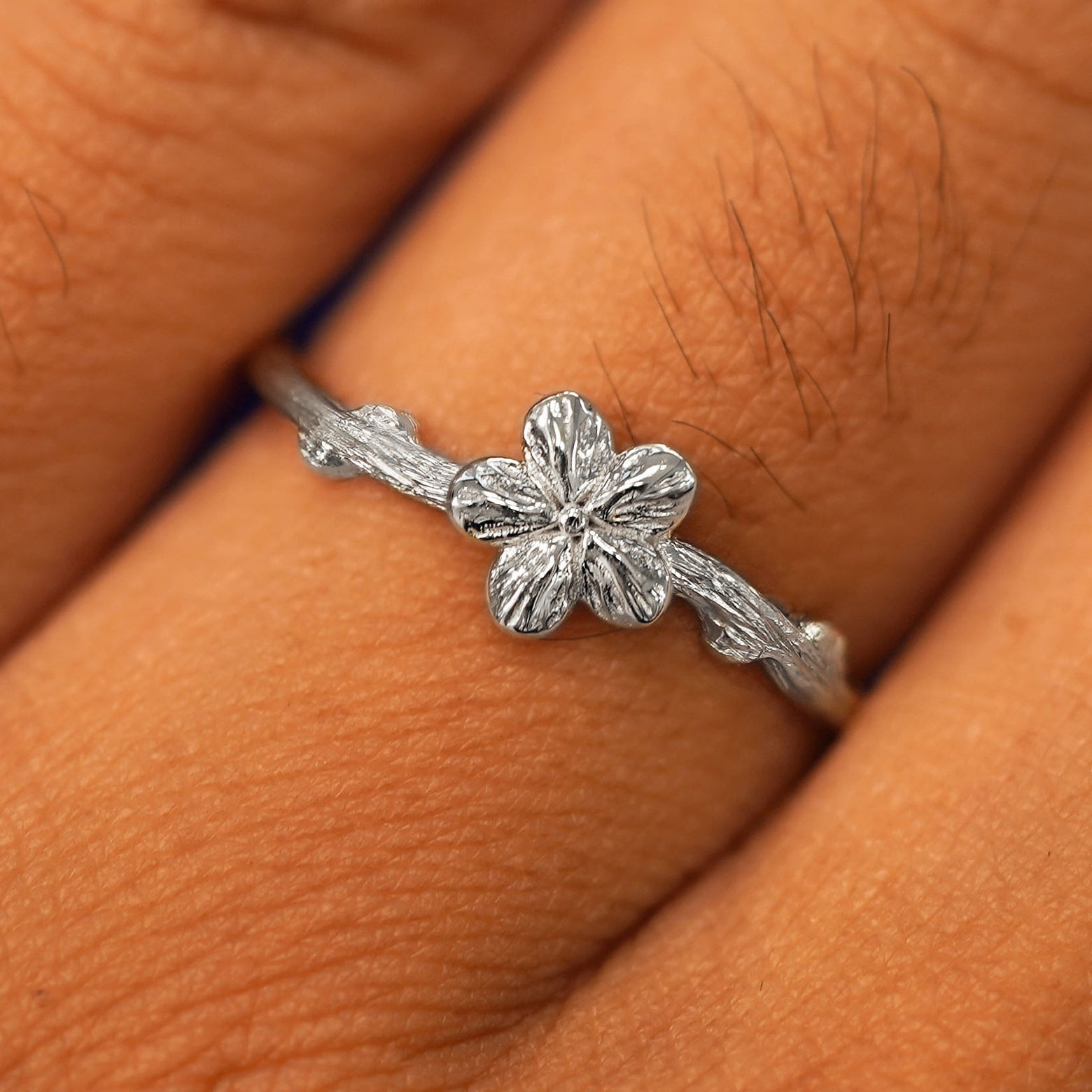 Close up view of a model's fingers wearing a 950 platinum Sakura Ring