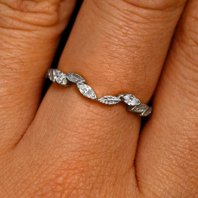 Close up view of a model's fingers wearing a 950 platinum Chevron Leaves and Marquise Diamonds Band