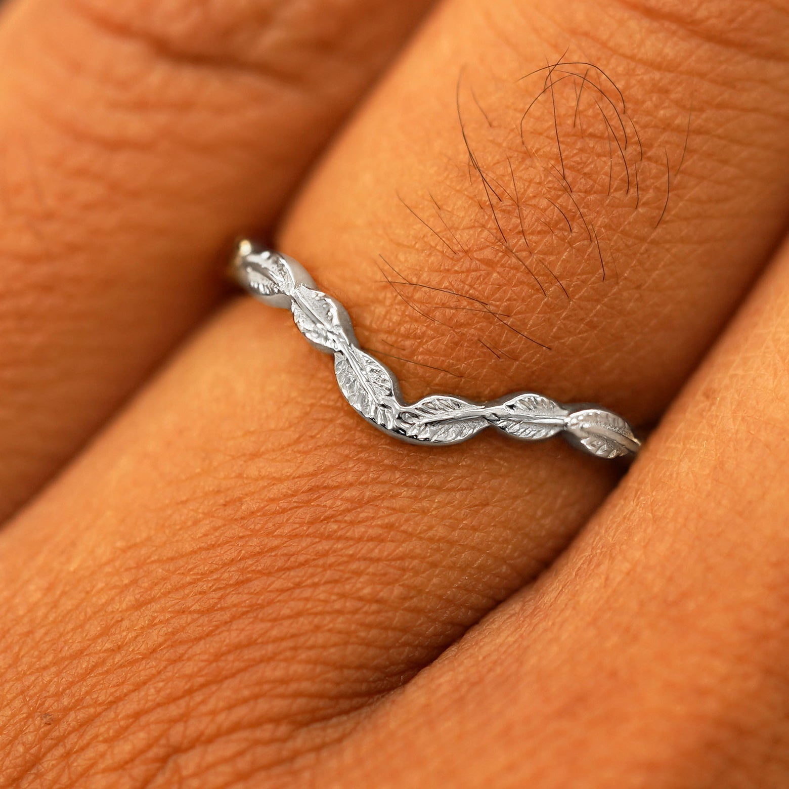 Close up view of a model's fingers wearing a 950 platinum Chevron Leaves Band