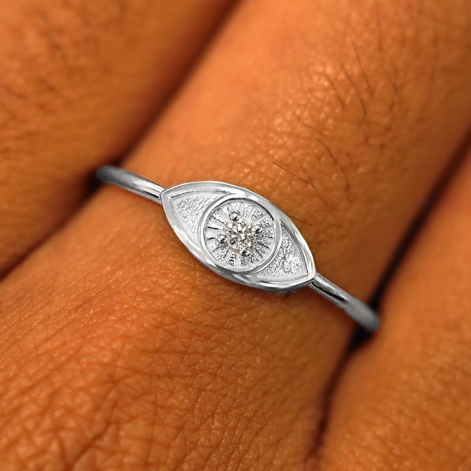 Close up view of a model's hand wearing a platinum Diamond Evil Eye Ring