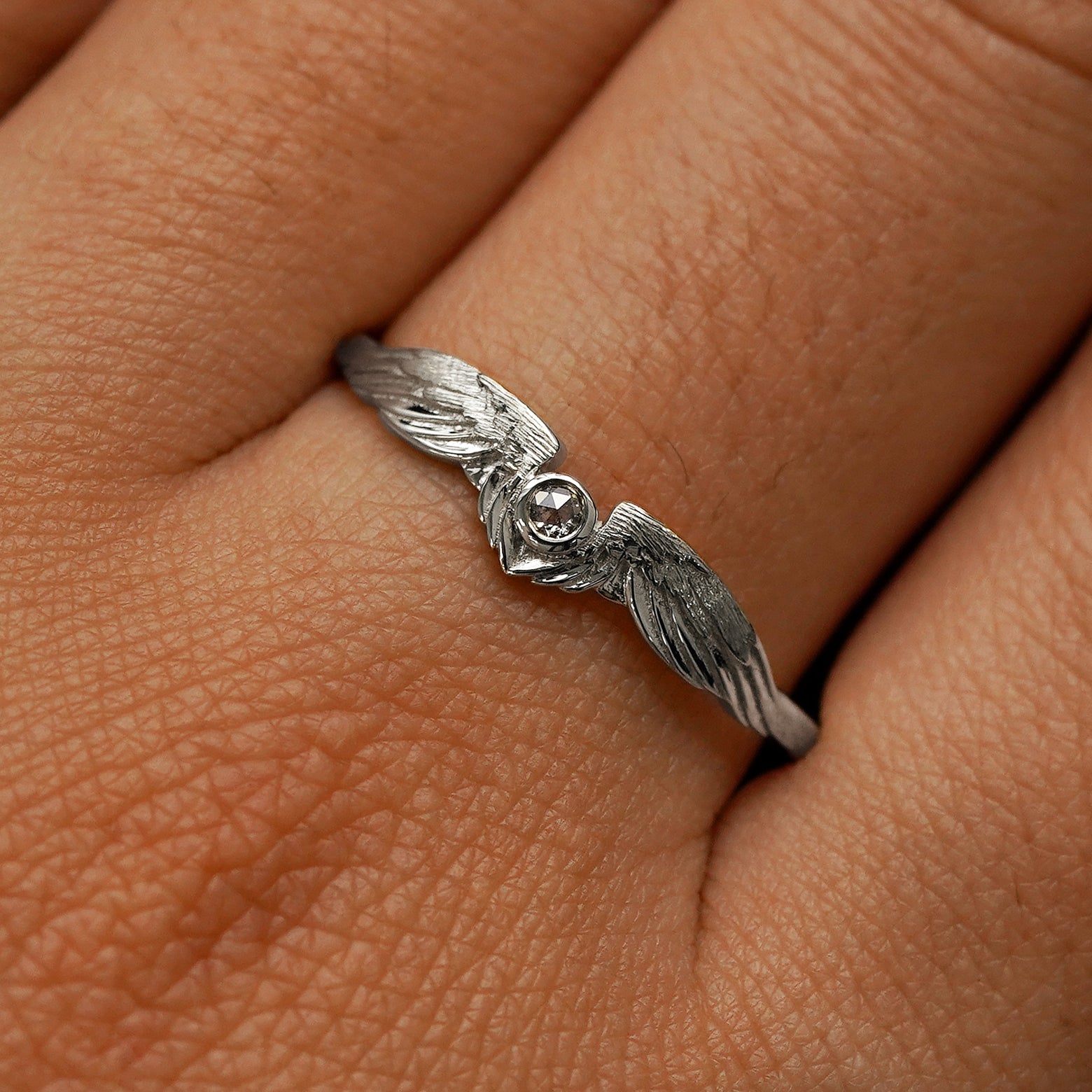 Close up view of a model's fingers wearing a 950 platinum Diamond Wings Ring
