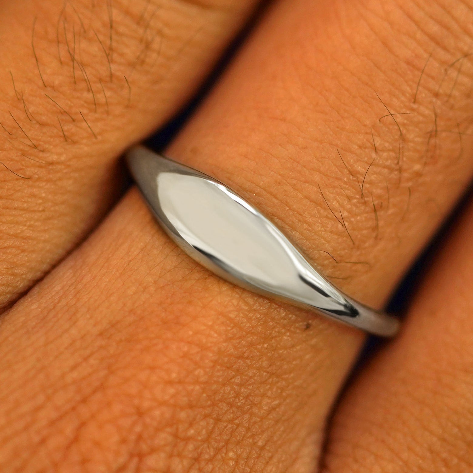 Close up view of a model's fingers wearing a 950 platinum Puffy Elongated Signet Ring