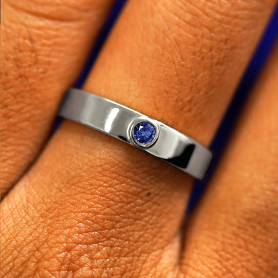Close up view of a model's fingers wearing a 950 platinum sapphire Gemstone Industrial Band