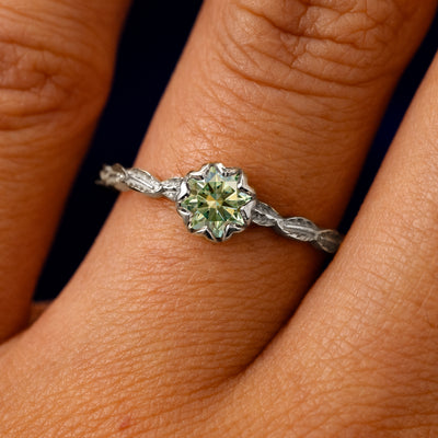 A solid 950 platinum Green Moissanite Leaf Ring on a model's finger