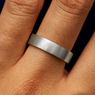 Close up view of a model's fingers wearing a 4mm 950 platinum Industrial Matte Band