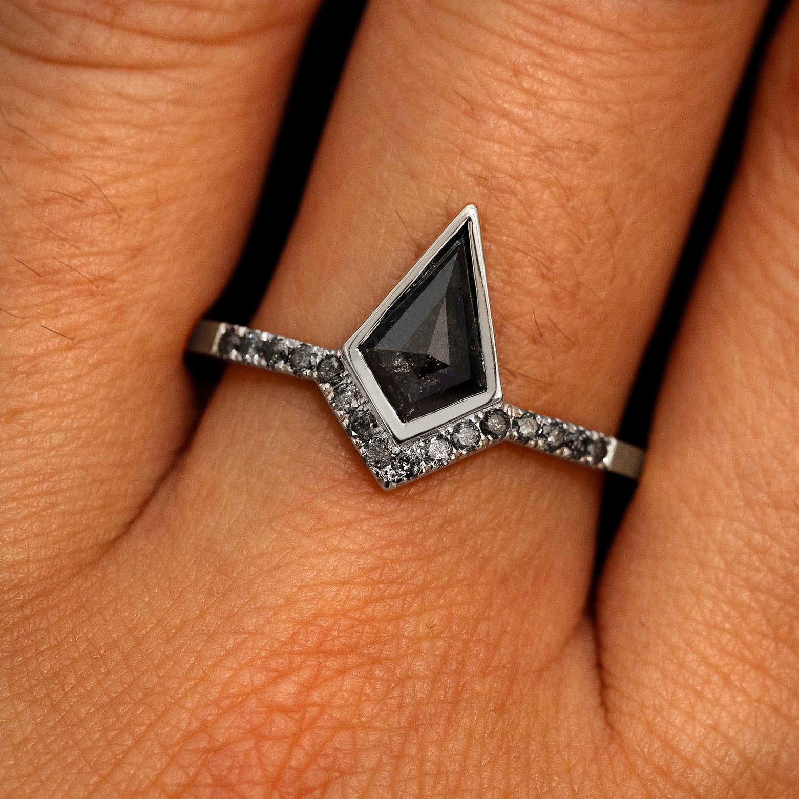 A model's hand wearing a 950 platinum Kite Salt and Pepper Diamond Pave Chevron Ring