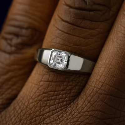 Close up view of a models hand wearing a 950 platinum asscher lab gemstone ring