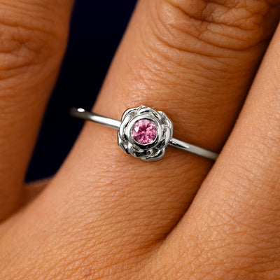 A solid 950 platinum Pink Sapphire Gemstone Flower Ring on a model's finger