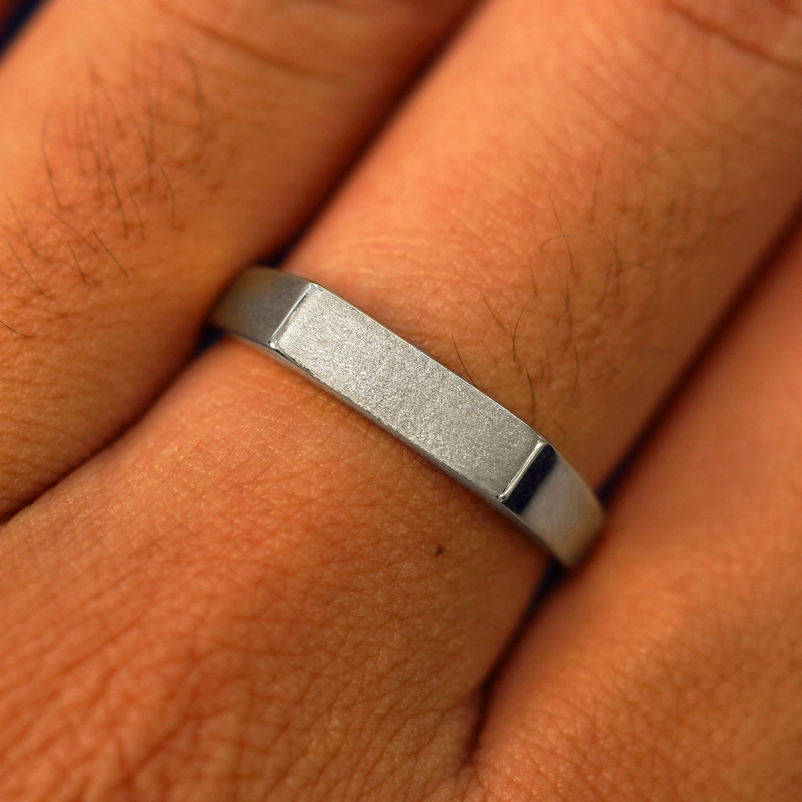 Close up view of a model's fingers wearing a 950 platinum Rectangular Signet Ring
