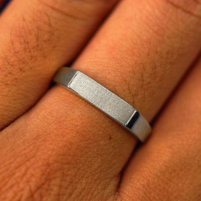 Close up view of a model's fingers wearing a 950 platinum Rectangular Signet Ring