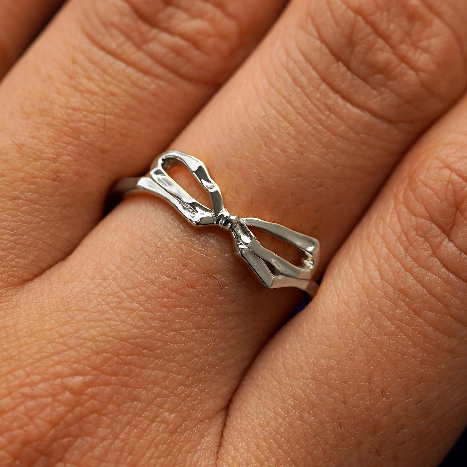 Close up view of a model's fingers wearing a 950 platinum Bow Ring