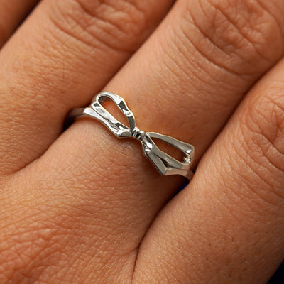 Close up view of a model's fingers wearing a 950 platinum Bow Ring