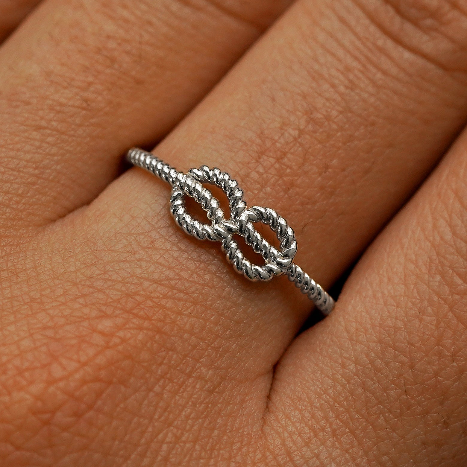 Close up view of a model's fingers wearing a 950 platinum Rope Infinity Ring