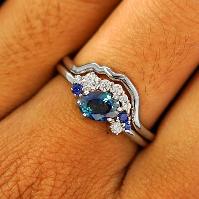 Close up view of a model's fingers wearing a 950 platinum Sapphire and Diamond Cluster Ring Set