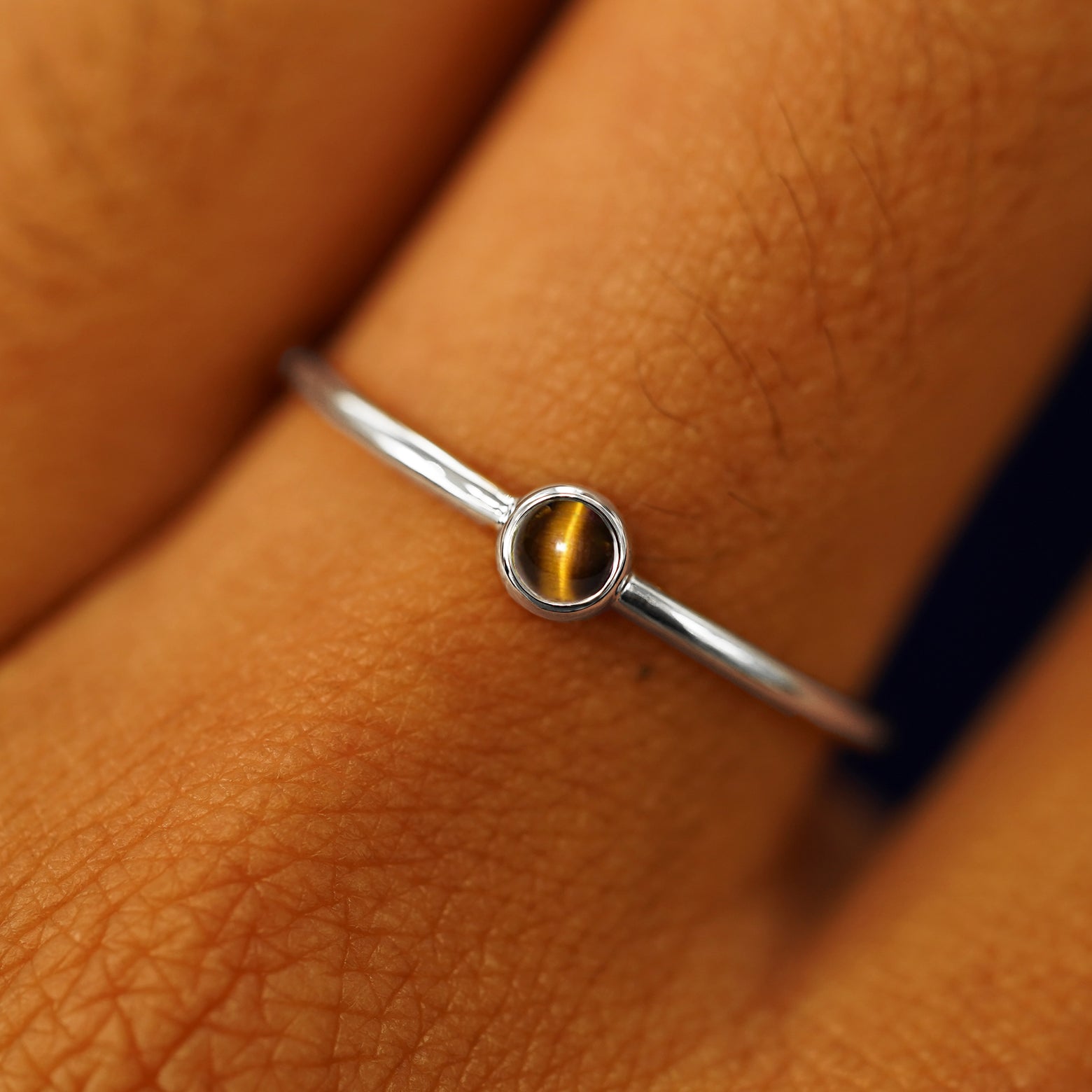Close up view of a model's fingers wearing a 950 platinum Tiger Eye Ring