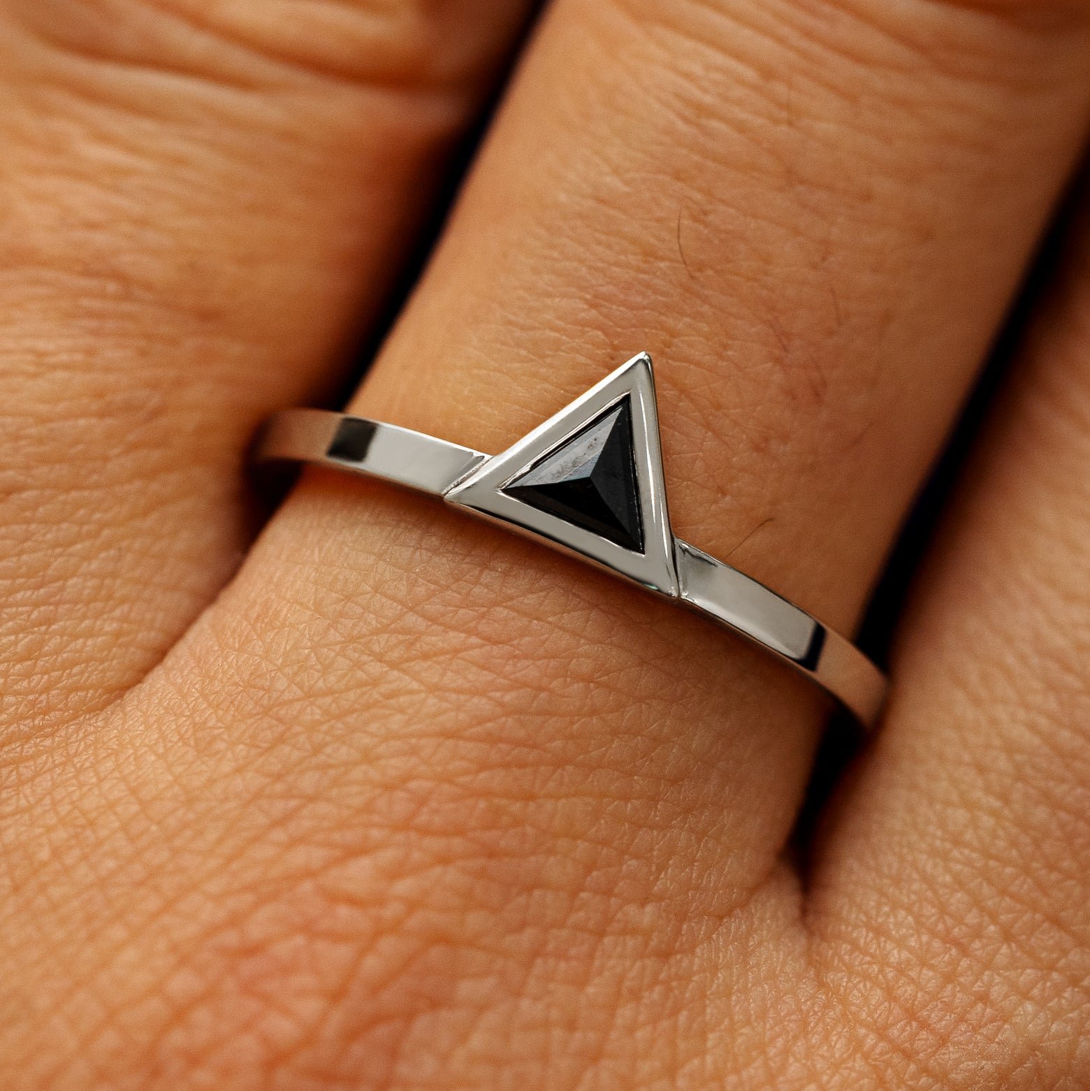 Close up view of a model's hand wearing a solid 950 platinum Triangle Diamond Ring