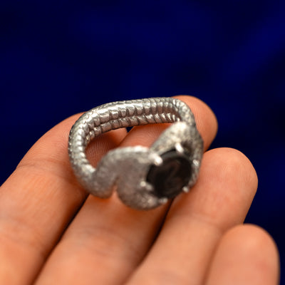 Sterling silver snake shaped statement ring balancing on a models fingertips