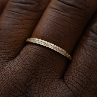 Close up view of a model wearing a solid 14k champagne gold geometric grass band