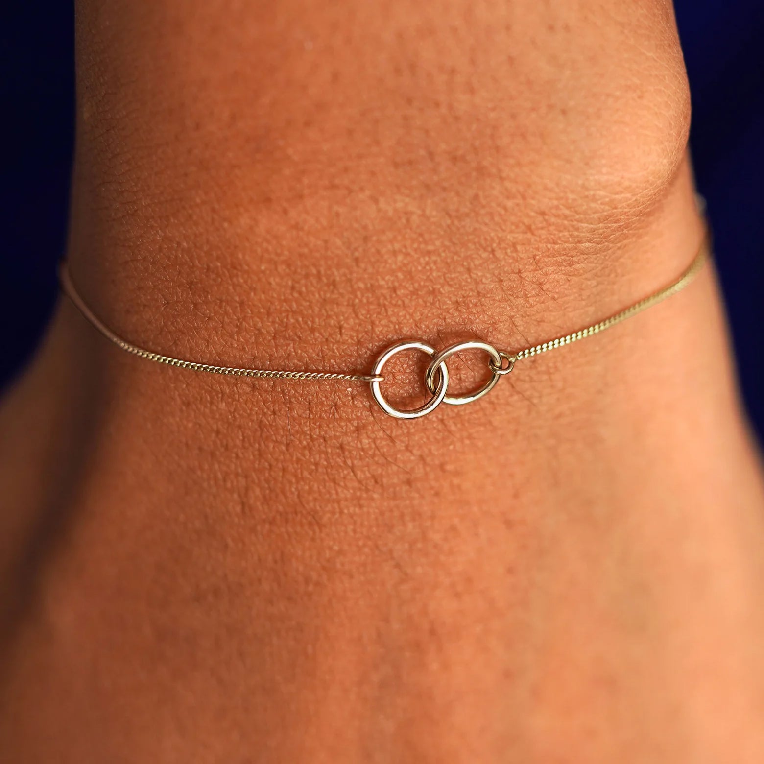 A model's wrist wearing a solid champagne gold Mini Bound Together Bracelet