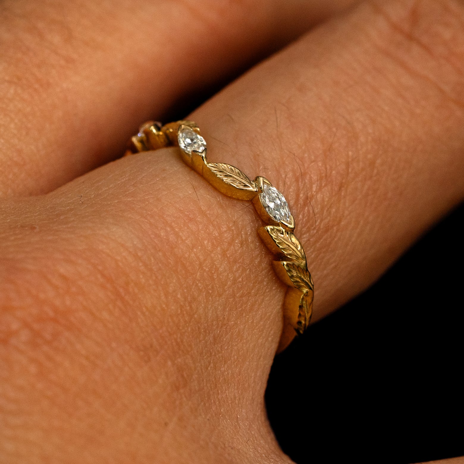 Side view of a Chevron Leaves and Marquise Diamonds Band on a model's finger