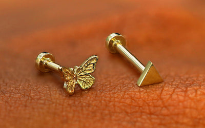 A mini butterfly flatback and a triangle flatback resting on the back of a model's hand
