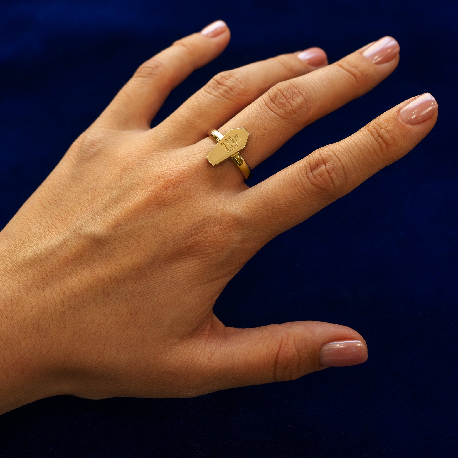 Close up view of a model's hand wearing a yellow gold Coffin Ring in the closed position